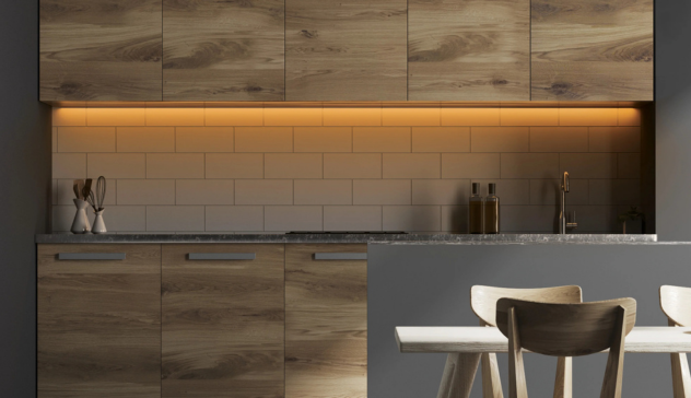 Show a warmly lit kitchen countertop illuminated by LED undercabinet lights, highlighting shaker cabinetry and a clean backsplash. The lighting should create contrast with natural light entering through a nearby window.