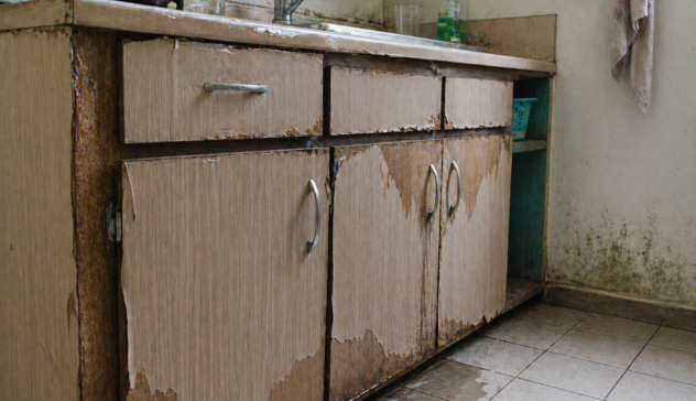 Swollen kitchen cabinets and damaged wood due to moisture and humidity exposure